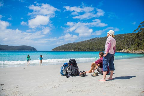 Photograph of a hiking family on the beach